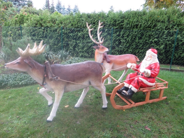 Zwei Rentierfiguren mit Schlitten und Weihnachtsmann als Gartendekoration